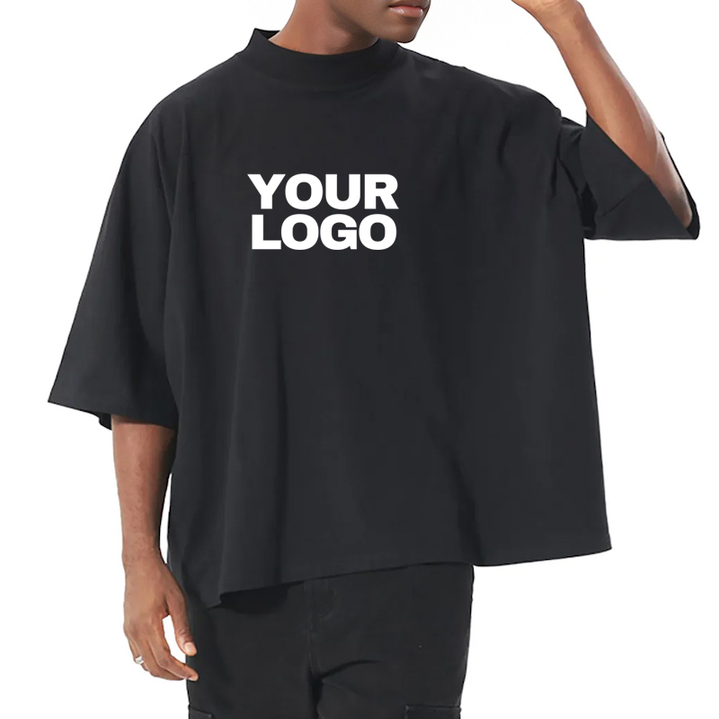 Homme portant un t-shirt personnalisé noir oversize avec logo blanc, style moderne et large